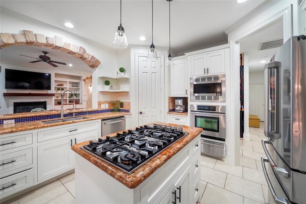 a kitchen with stainless steel appliances granite countertop a stove a sink and a refrigerator