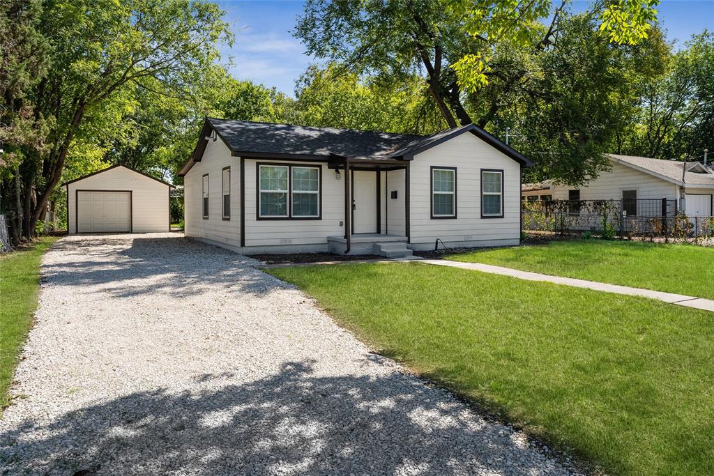 a front view of a house with a yard and trees