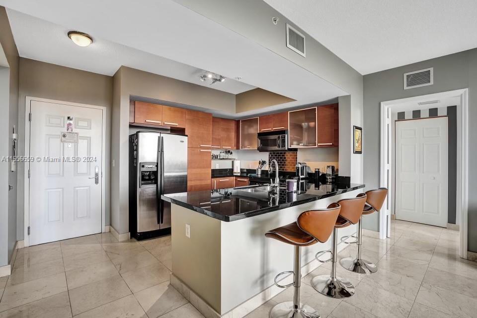 a kitchen with stainless steel appliances granite countertop a refrigerator and a stove