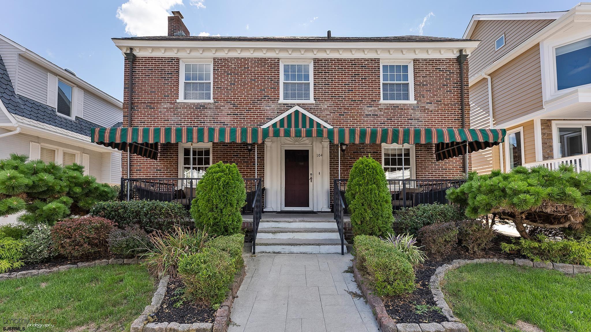 a front view of a house with garden and entryway