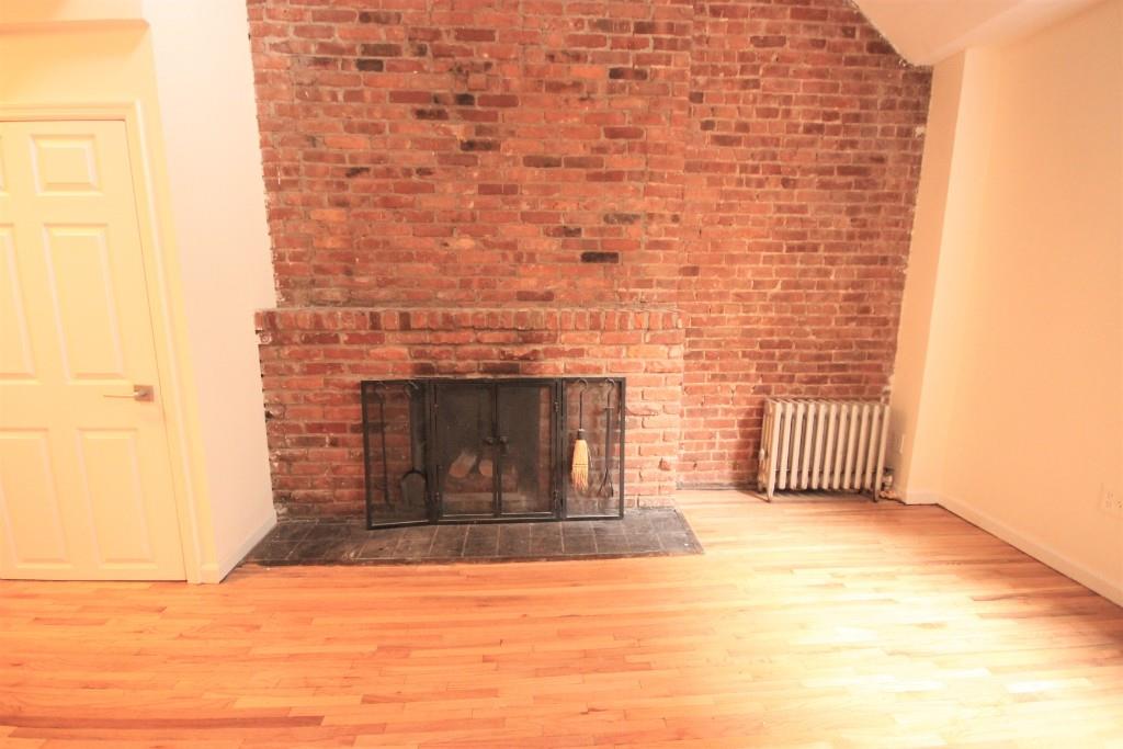 a view of empty room with a fireplace