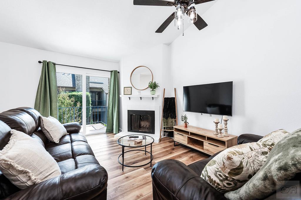 a living room with furniture a flat screen tv and a fireplace