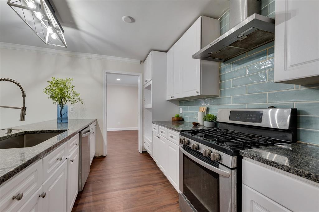 a kitchen with stainless steel appliances granite countertop a sink stove and cabinets