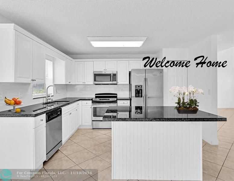 a kitchen with stainless steel appliances granite countertop a sink and cabinets