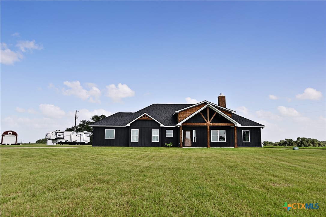 a view of a house with a yard and wooden fence