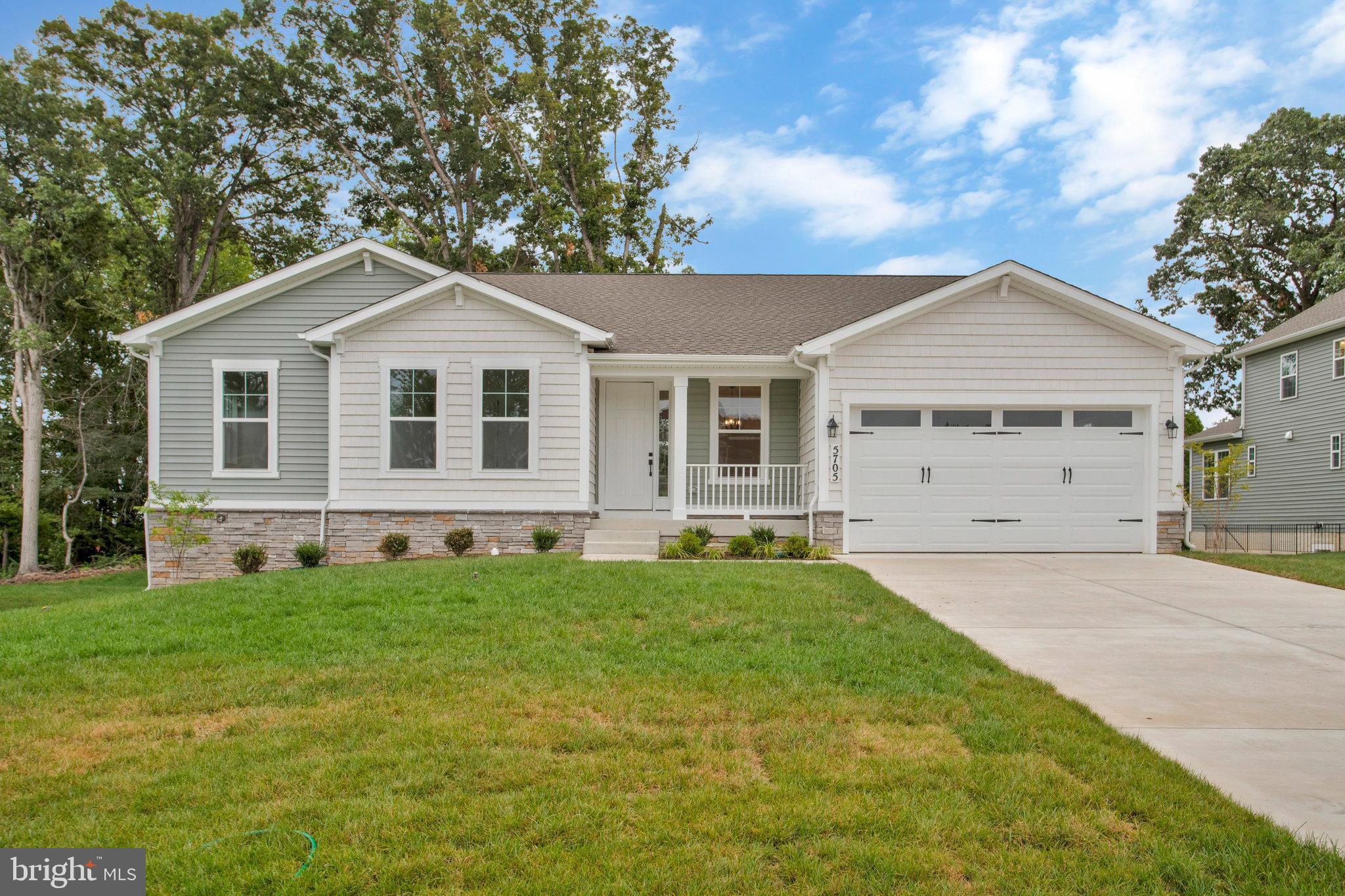 a front view of a house with a garden and yard