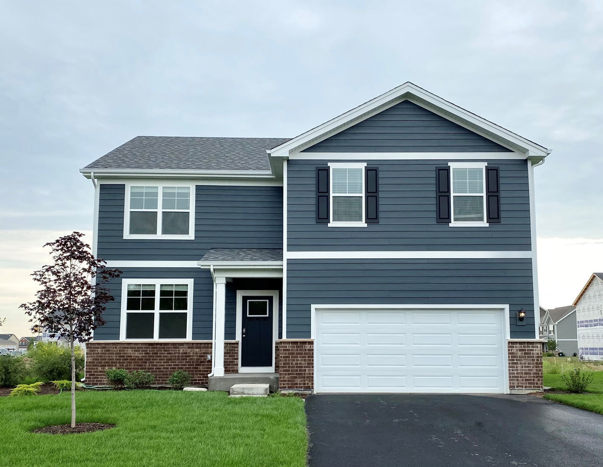 a front view of a house with a yard and garage