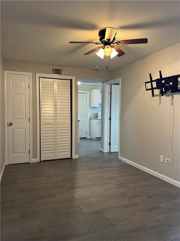 an empty room with closet and chandelier fan