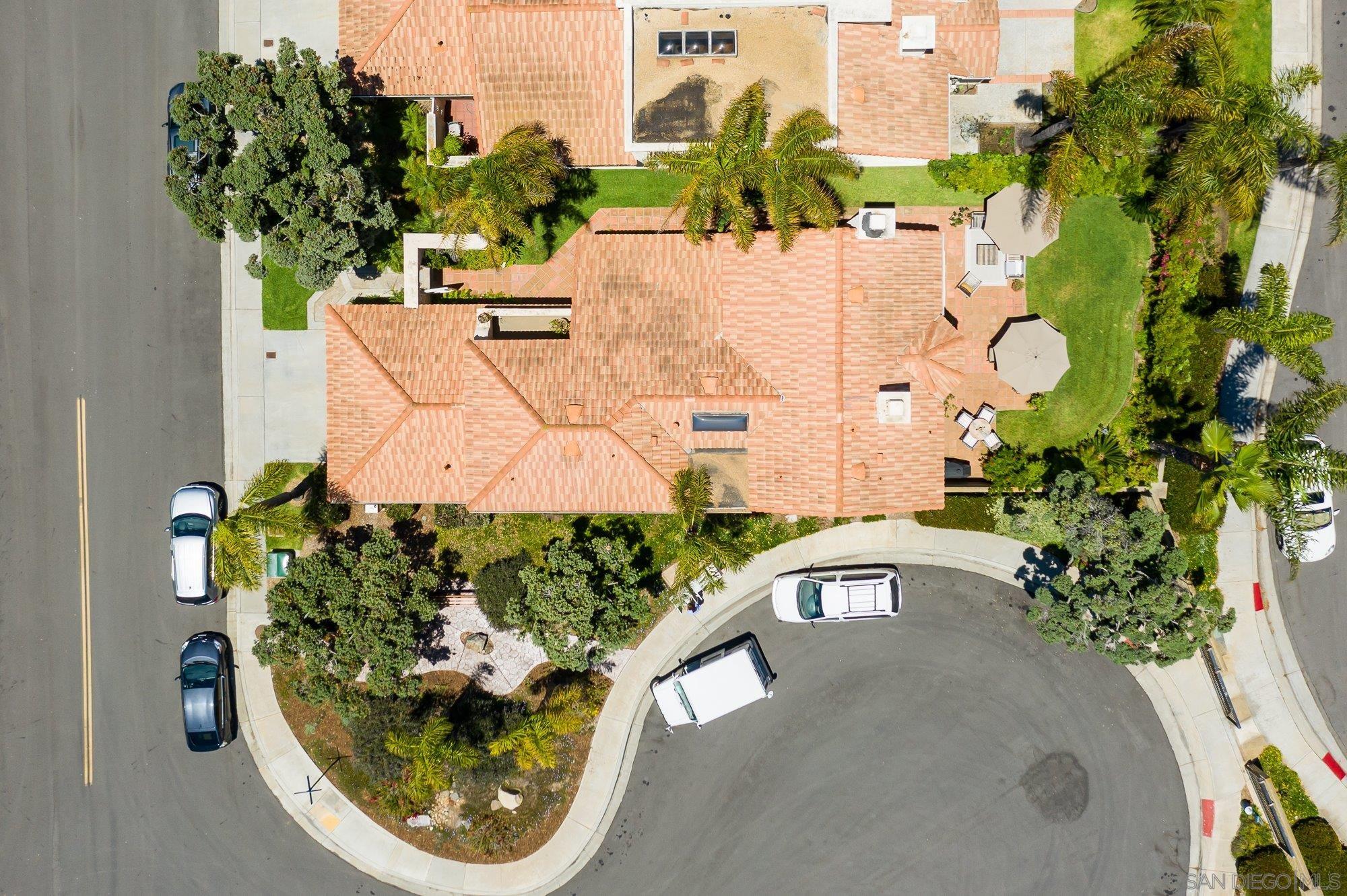 an aerial view of a house with a yard and large trees