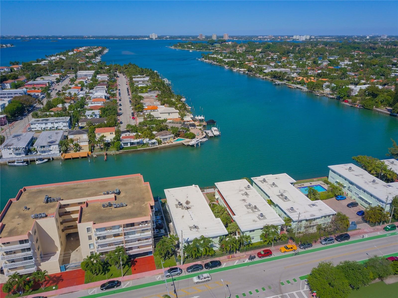 an aerial view of a city with lots of residential buildings ocean and mountain view in back