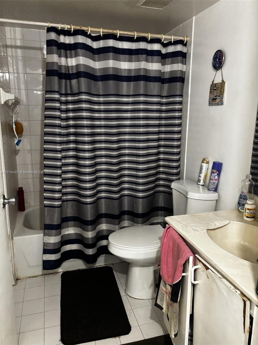 a bathroom with a sink a toilet and shower curtain