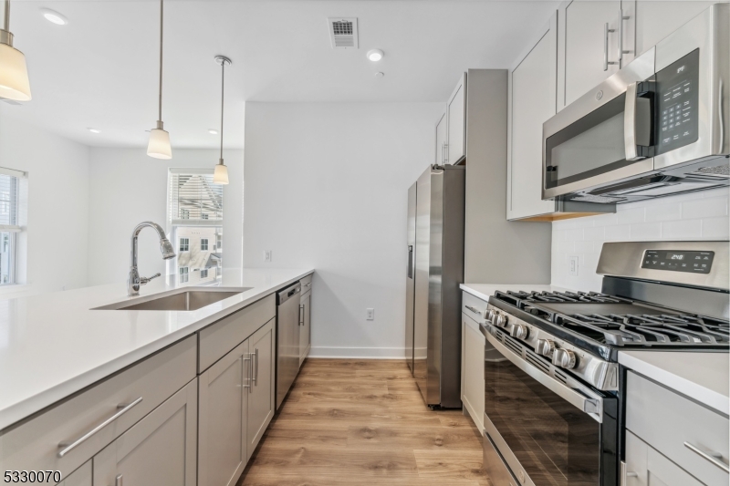 a kitchen with stainless steel appliances a sink stove and refrigerator