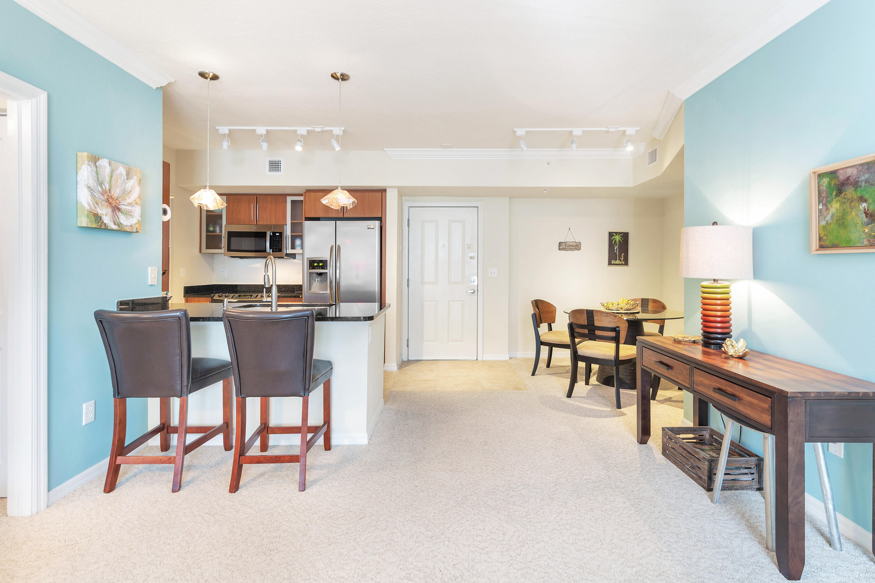 a living room with stainless steel appliances kitchen island granite countertop furniture and a dining table