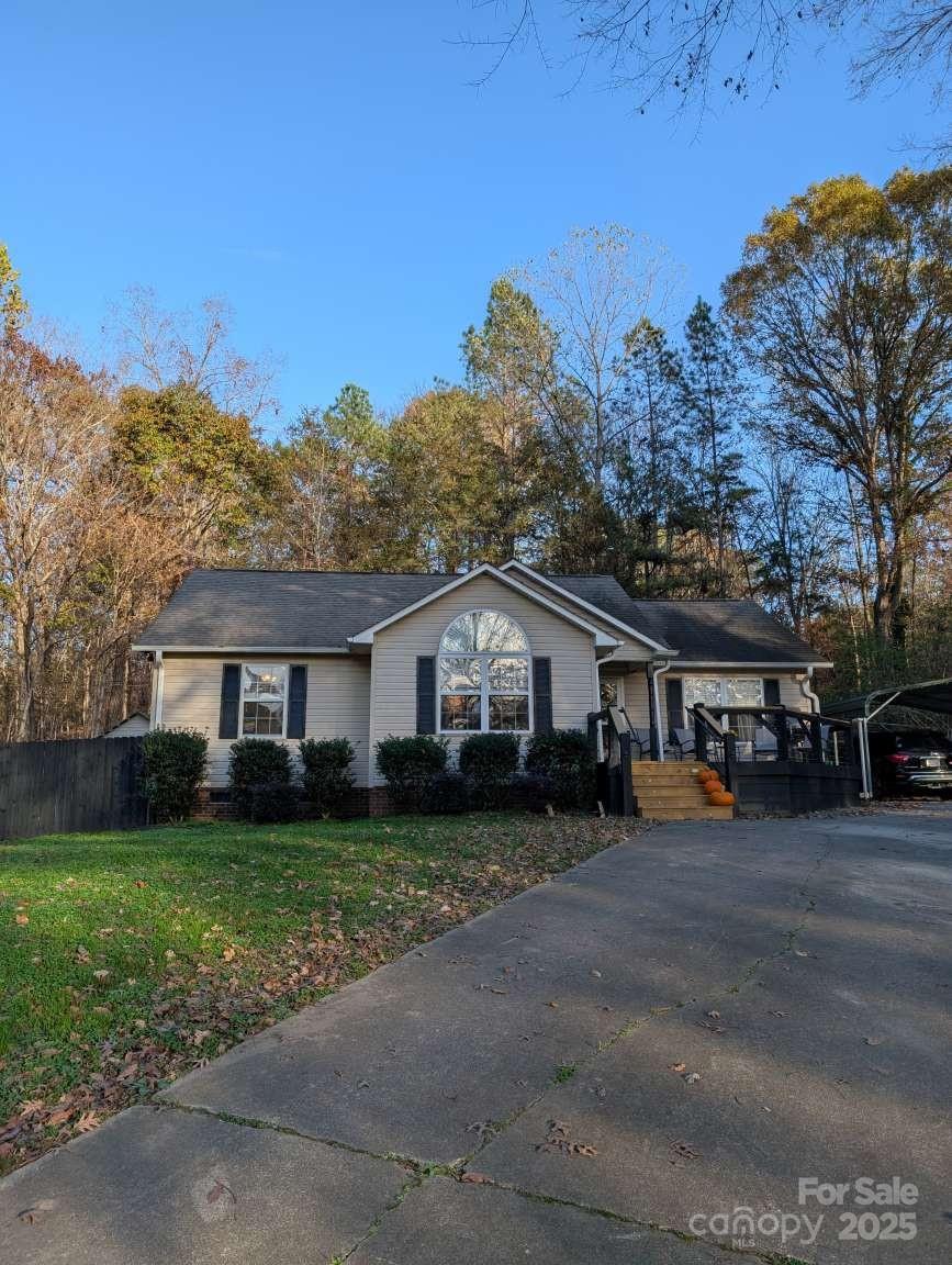 a view of a house with a big yard and large trees