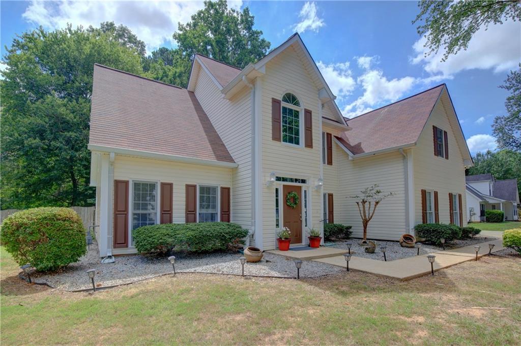 a view of house with yard and outdoor seating