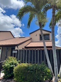 a view of a house with a small yard plants and large tree