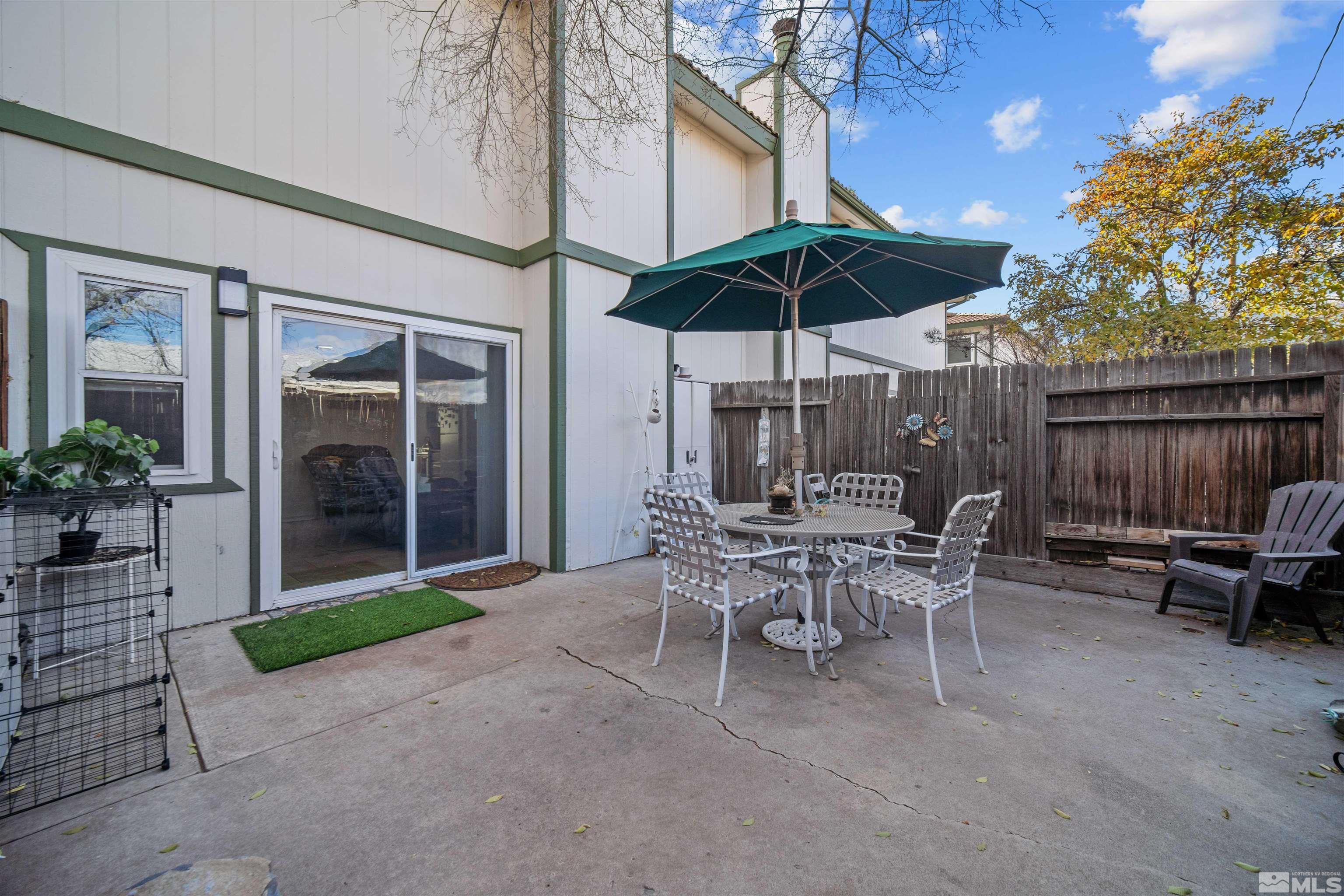 a view of a patio with a table and chairs under an umbrella