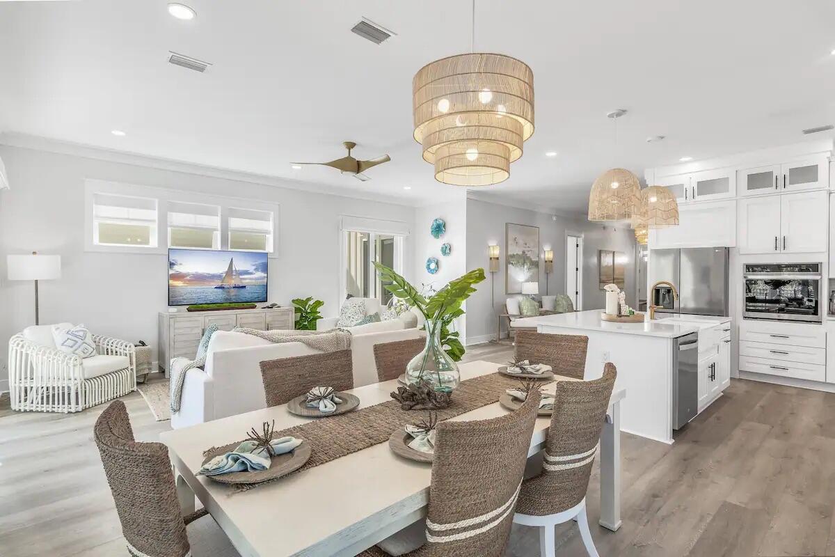 a view of a dining room with furniture a kitchen and chandelier