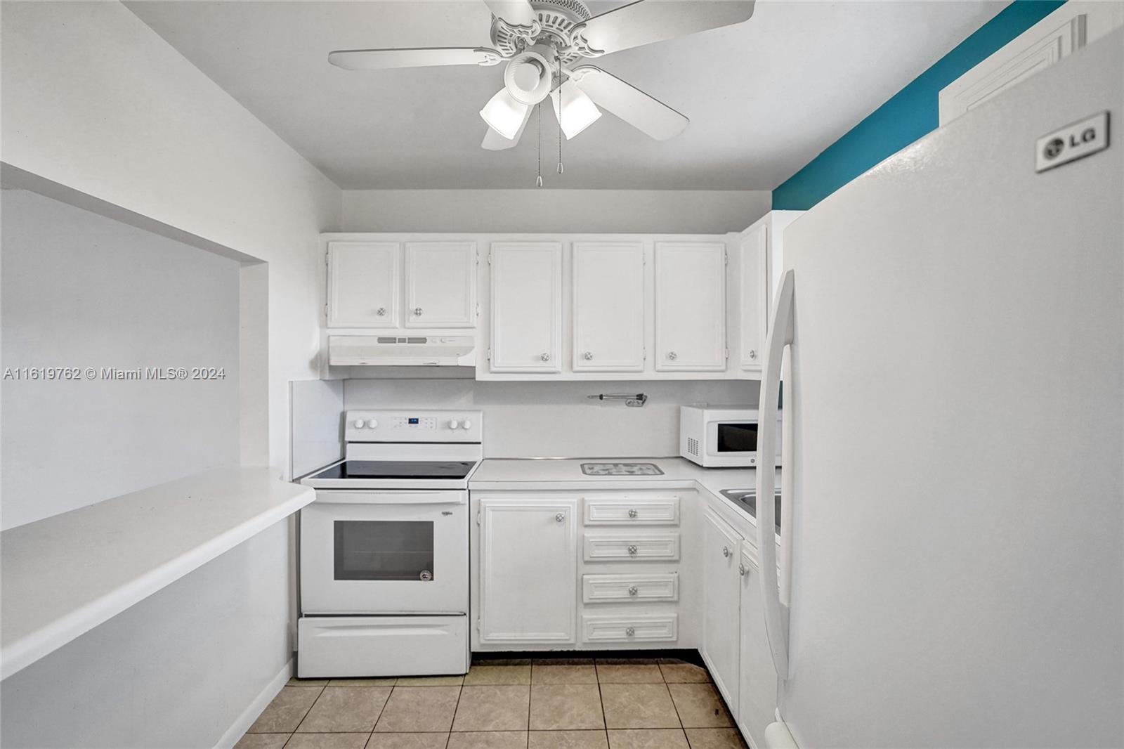 a kitchen with white cabinets and white appliances