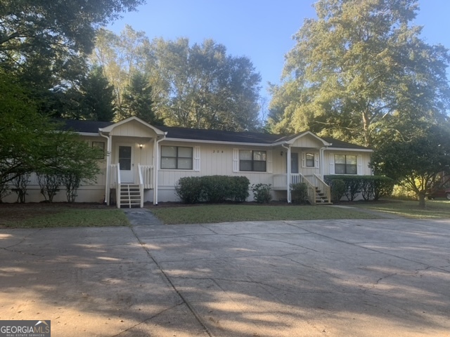 a front view of a house with a yard and trees