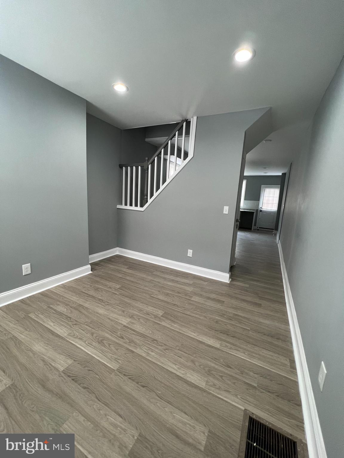 a view of an empty room with wooden floor