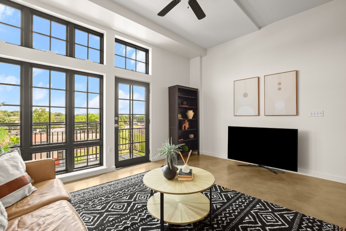 a living room with furniture a fireplace and a large window