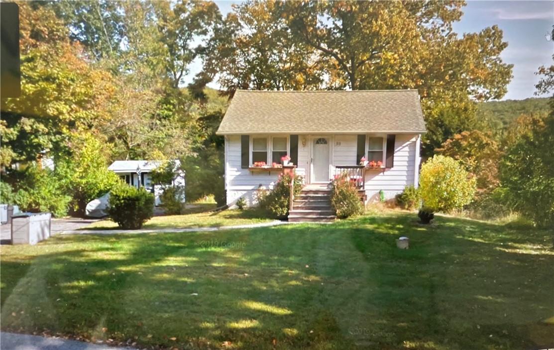 View of front of house featuring a front yard & shed