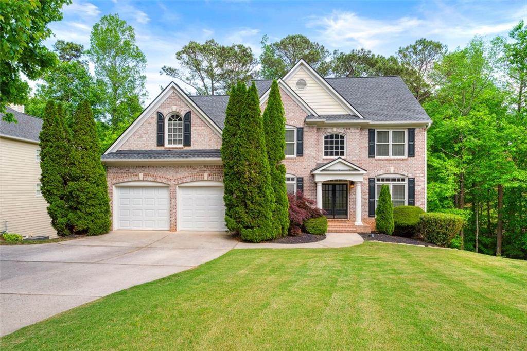 a front view of a house with a yard and garage