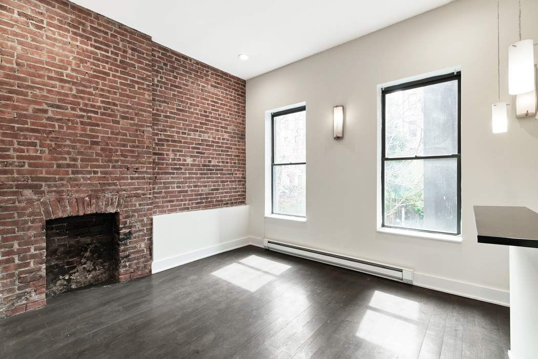 an empty room with windows and fireplace