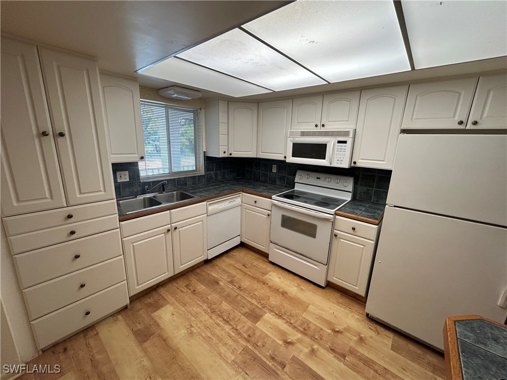 a kitchen with white cabinets and white appliances