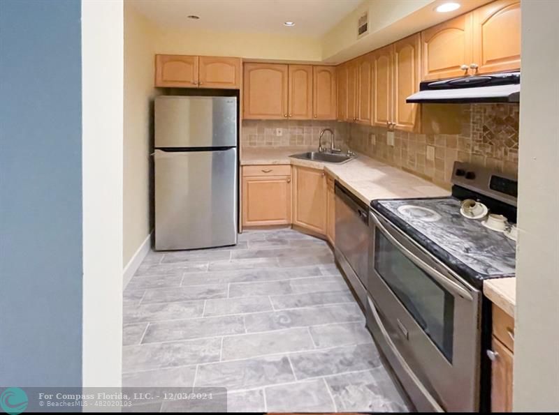 a kitchen with a stove a refrigerator and a sink