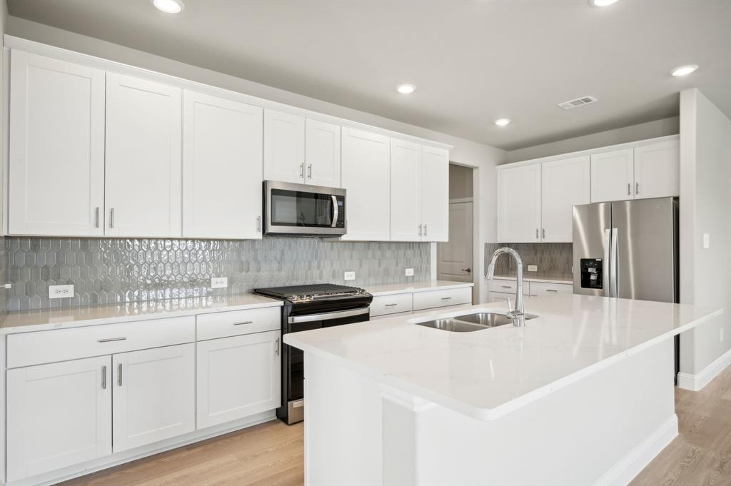 a kitchen with appliances a sink and cabinets