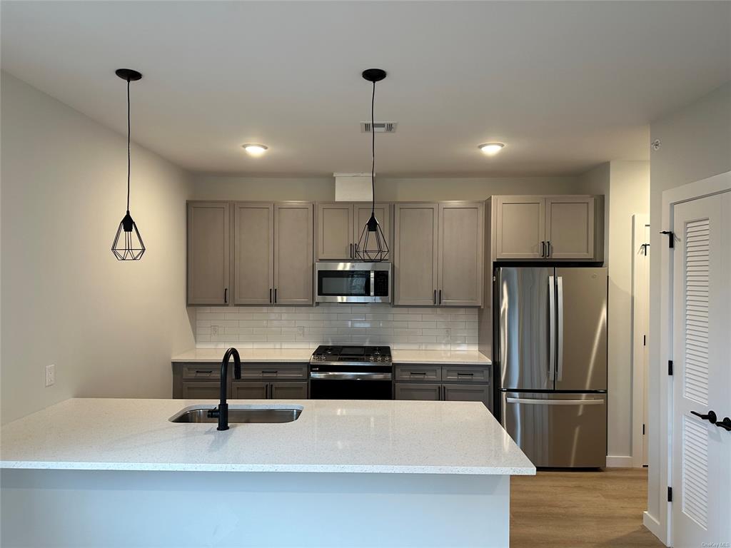 a kitchen with kitchen island a sink stainless steel appliances and cabinets