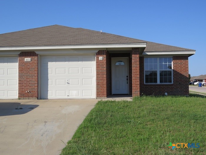 a front view of a house with a garden and garage