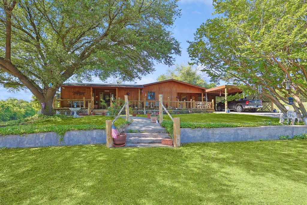 a front view of house with yard swimming pool and green space