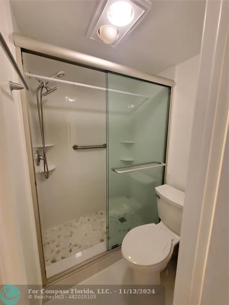 a bathroom with a toilet and a shower