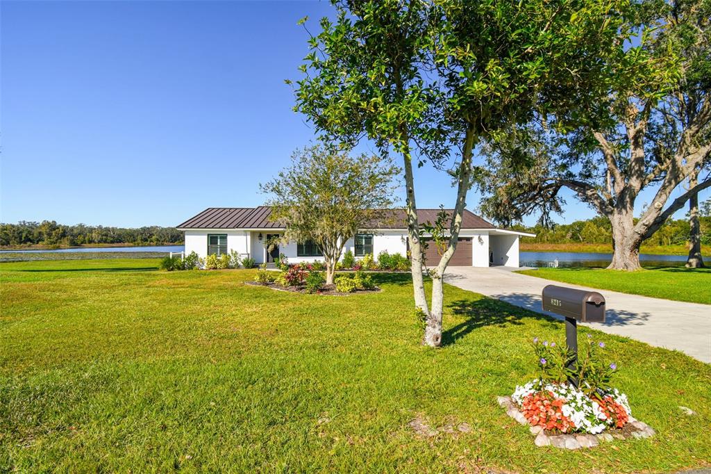 a front view of a house with swimming pool garden and outdoor seating