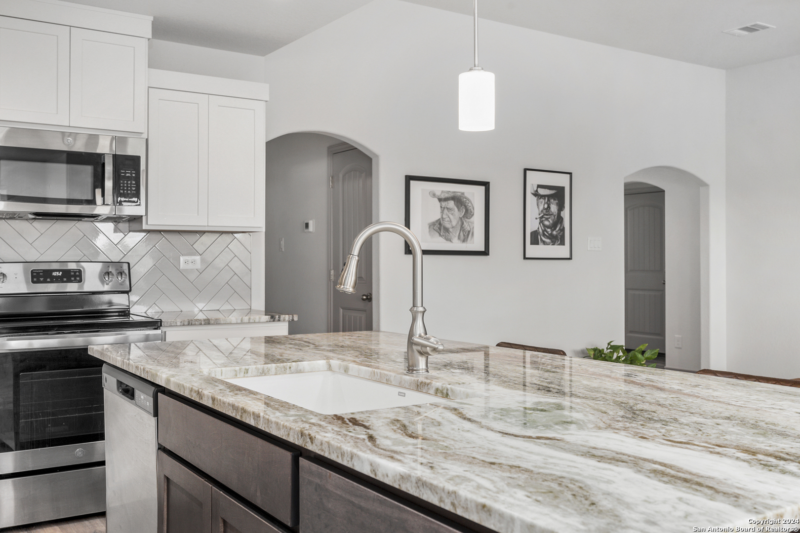 a kitchen with granite countertop a sink stainless steel appliances and cabinets