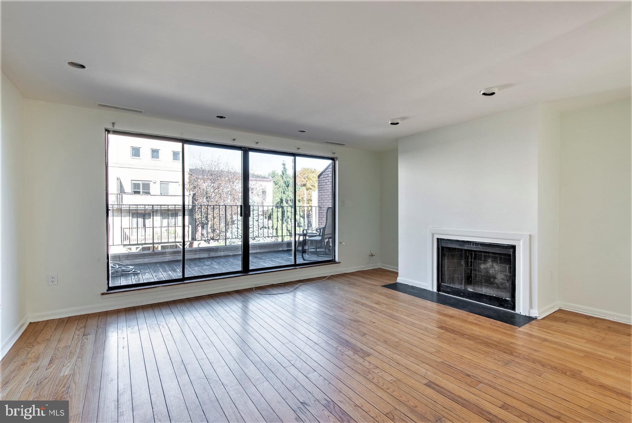 wooden floor fireplace and windows in an empty room