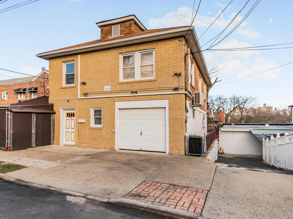 Back of house featuring cooling unit and a garage