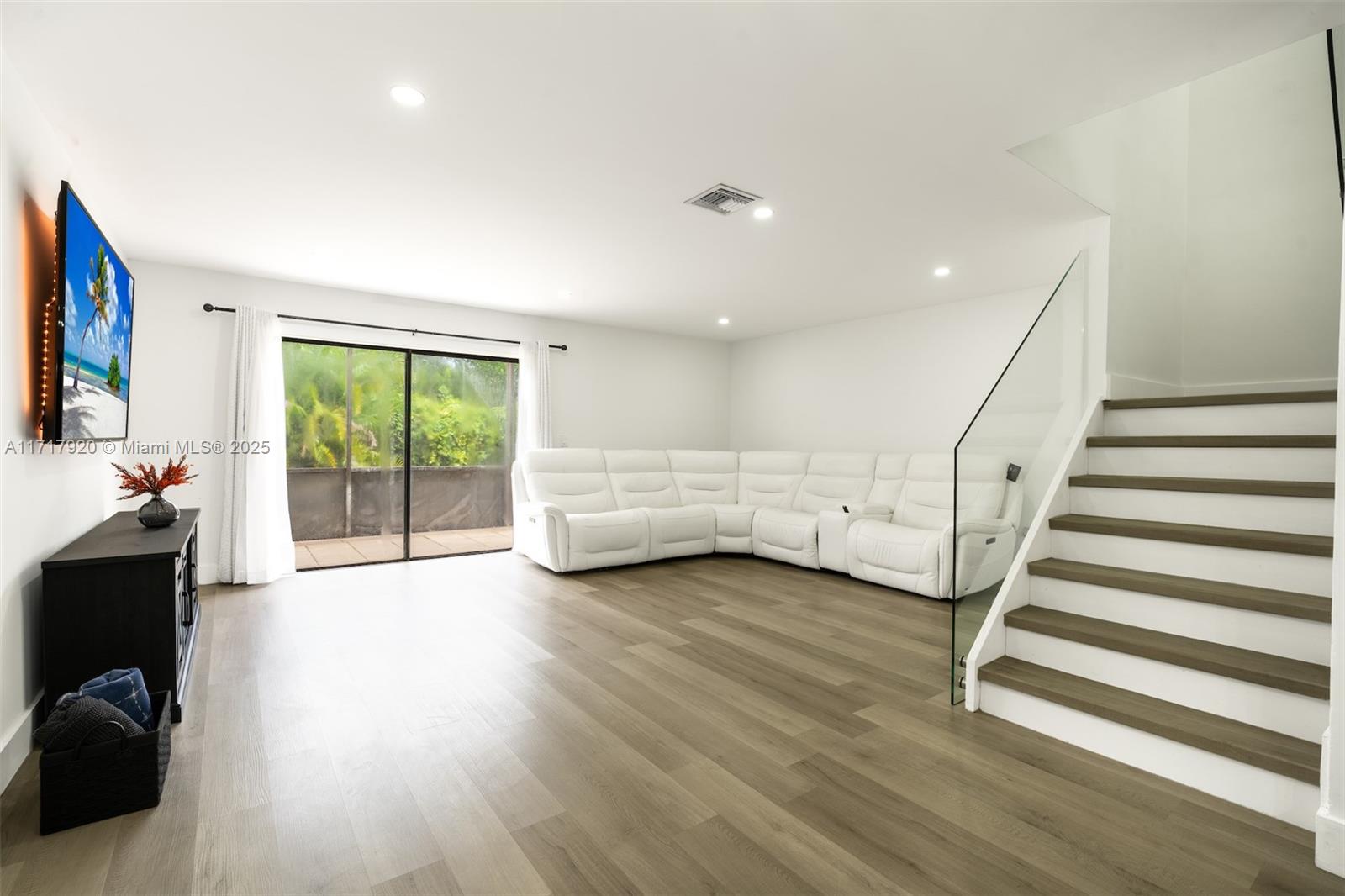 a view of an empty room wooden floor and a window