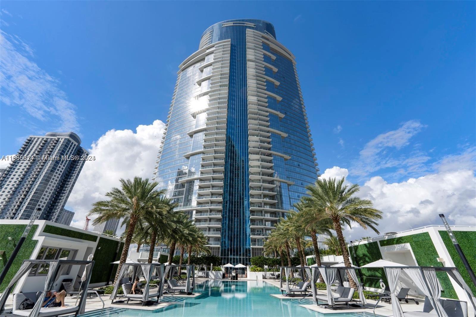 a view of a tall building with a palm tree next to a tall building