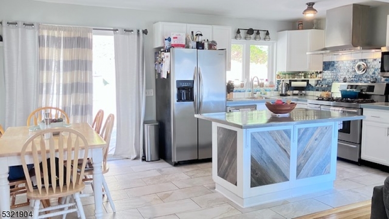 a kitchen with stainless steel appliances granite countertop a refrigerator and a stove