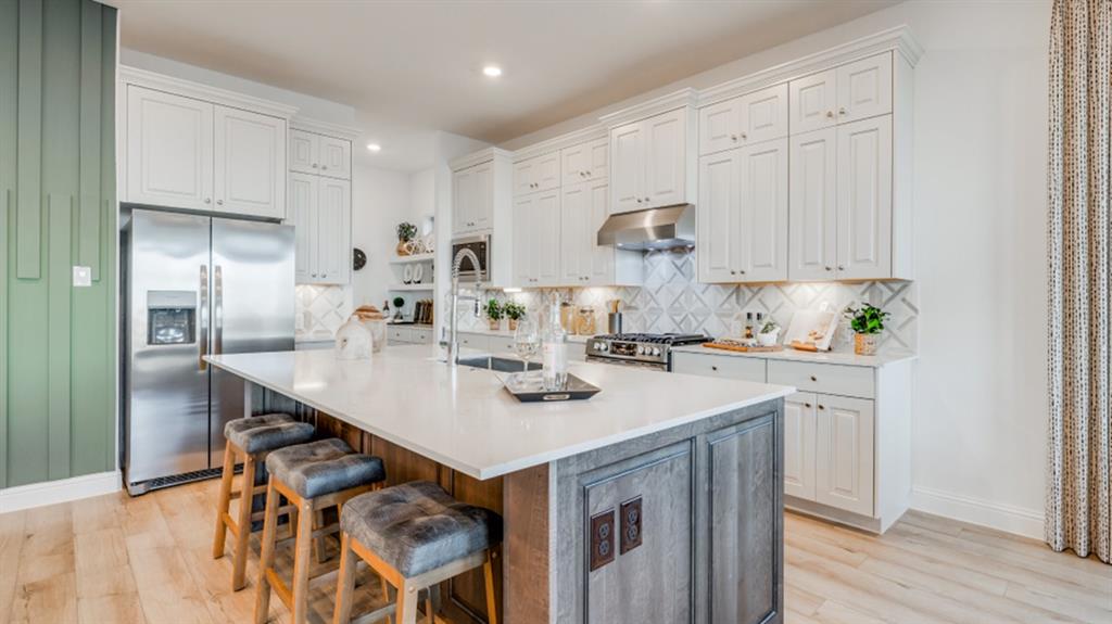 a kitchen with stainless steel appliances granite countertop a sink a stove and a refrigerator