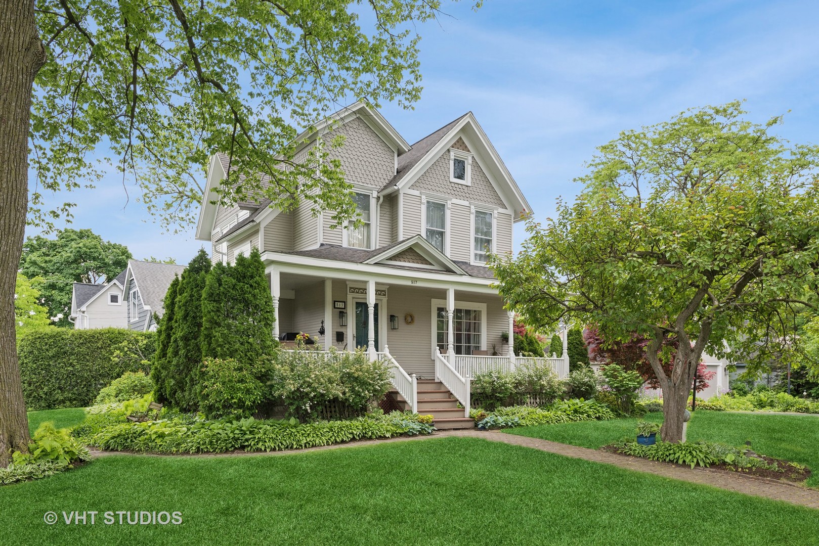 a front view of a house with a yard and trees