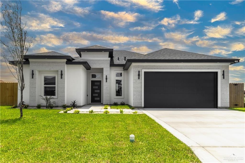 a front view of a house with a yard and garage