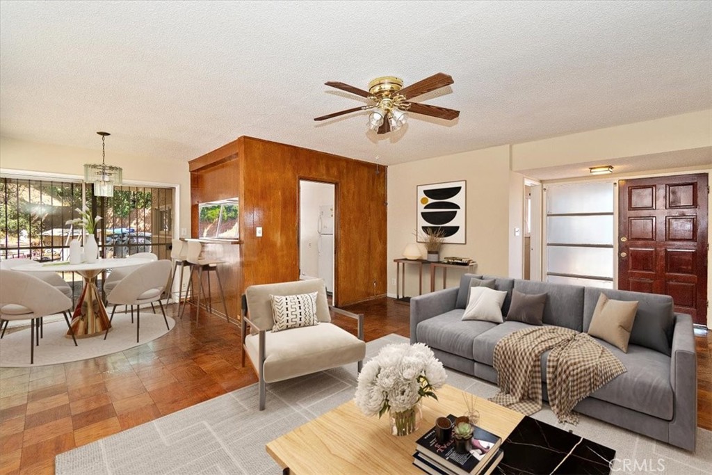 a living room with furniture wooden floor and a large window