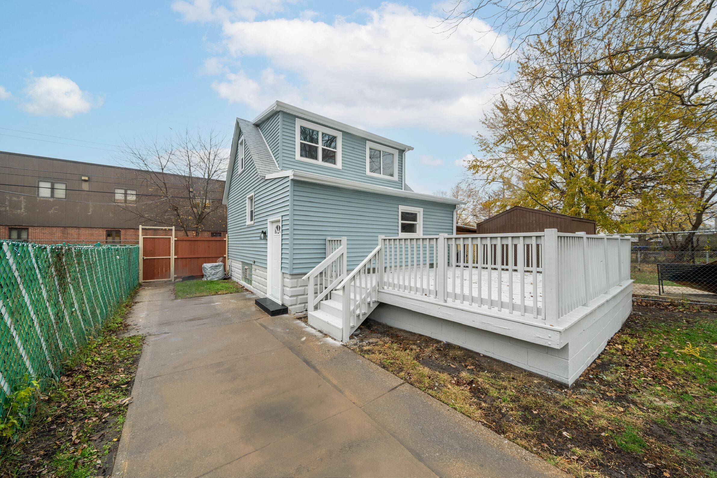 a view of a house with a wooden fence and a floor to ceiling window