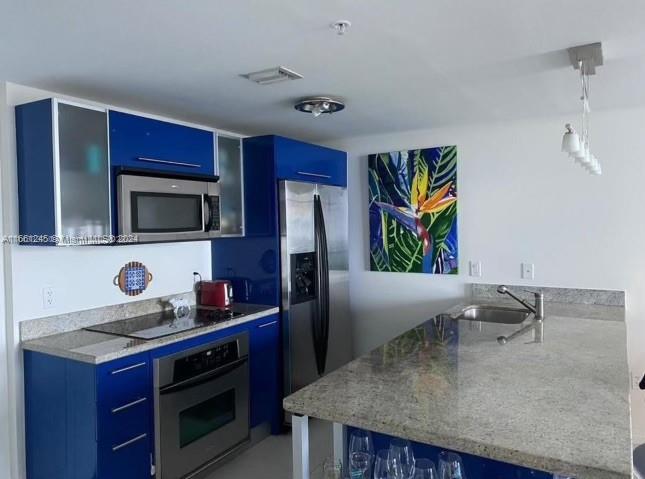 a kitchen with stainless steel appliances granite countertop a sink a stove and a refrigerator