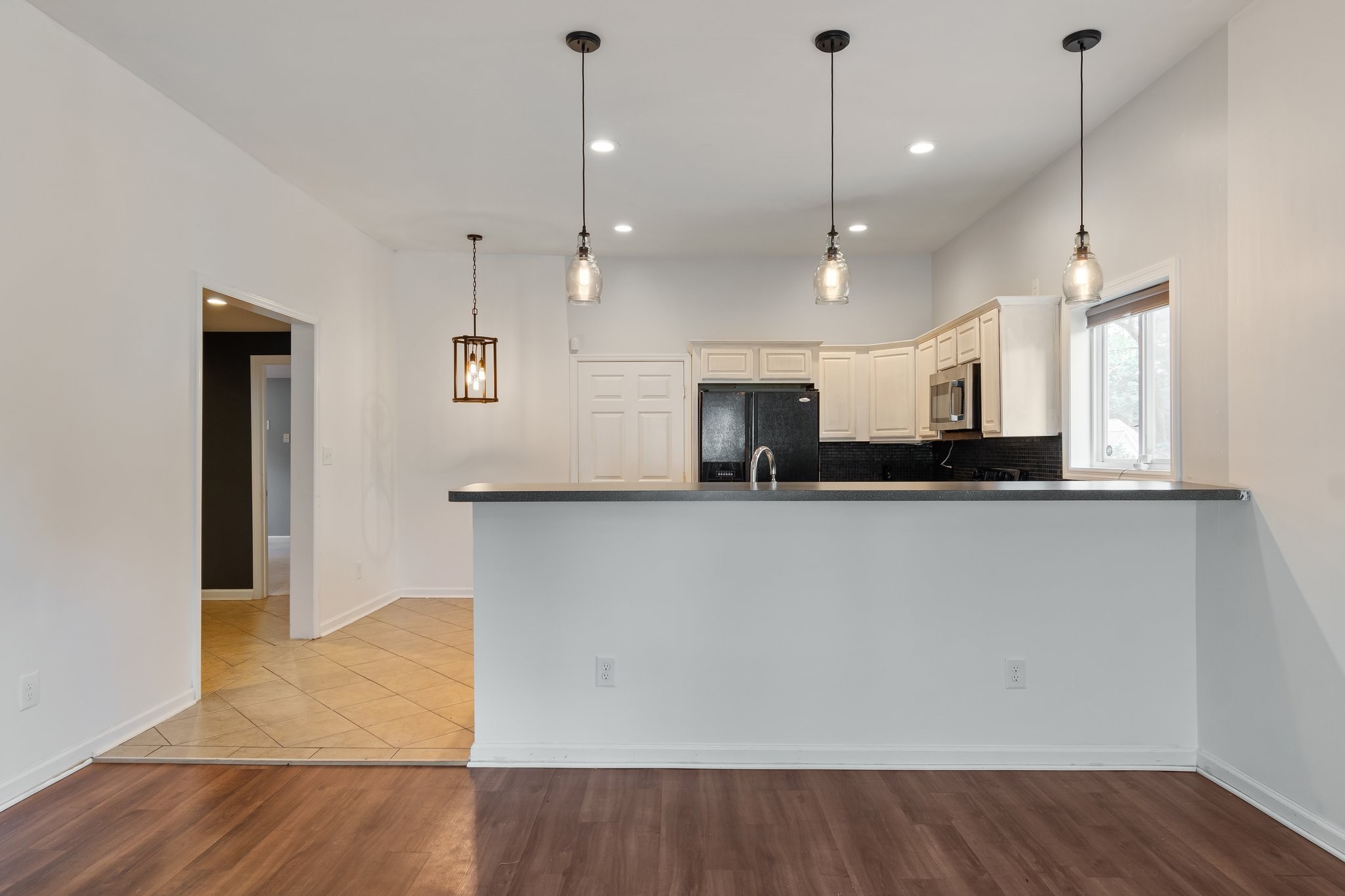 a view of a kitchen with a sink and refrigerator